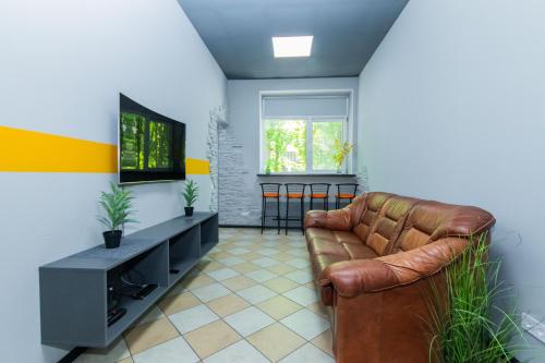 a living room with a couch and a television at Seven Apart Hotel in Vyshneve