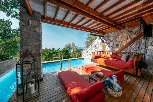 a wooden deck with a couch and a pool at Nautical Hotel in Faralya