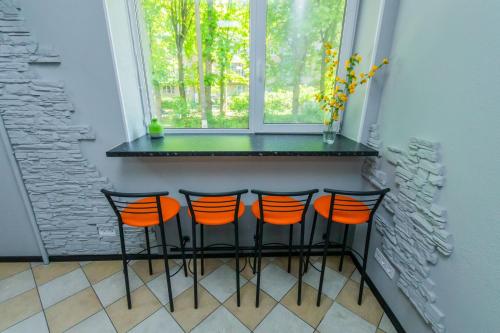 a small bar with four chairs in front of a window at Seven Apart Hotel in Vyshneve