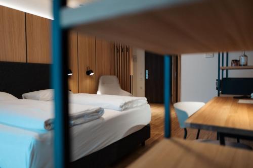 una camera d'albergo con letto, tavolo e sedie di eduCARE Hotel a Treffen
