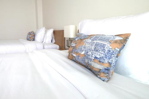 a white bed with a pillow on top of it at River View Pathum Hotel and Residence in Pathum Thani