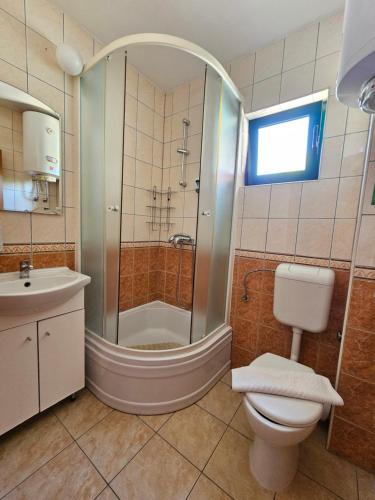 a bathroom with a shower and a toilet and a sink at Hotel Prvan in Vrgorac