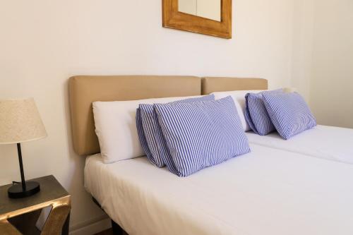 Una cama con dos almohadas azules y blancas. en Valencia Luxury - Malvarrosa Beach en Valencia
