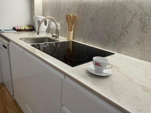 a kitchen counter with a sink and a coffee cup at Apartamenty na Starówce - Apartments in the Old Town in Cieszyn