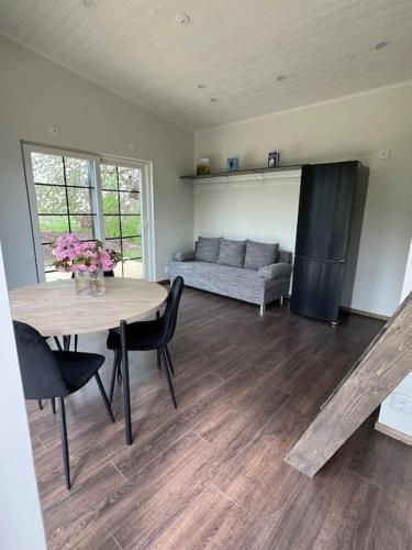 a living room with a table and a couch at Attefallare i äppelriket in Vånga