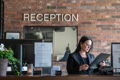 a woman sitting at a counter with a laptop at Kviberg Park Hotel & Conference in Gothenburg