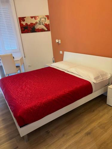 um quarto com uma cama com um cobertor vermelho em New Caos Calmo em Roma