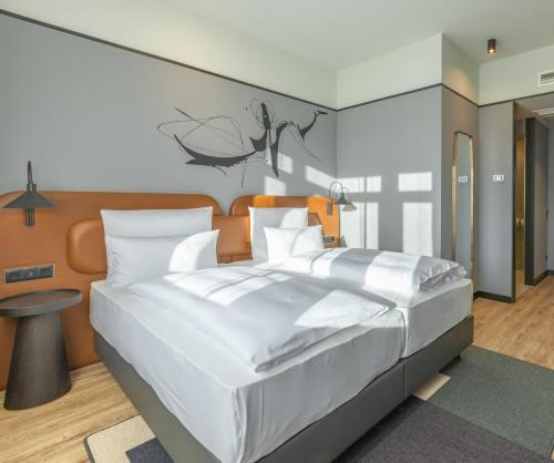 TITANIC Comfort Kurfürstendamm في برلين: غرفة نوم بسرير ابيض كبير وطاولة