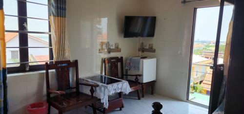 a room with a refrigerator and a tv on the wall at Dong Hai Hotel in Phú Vang