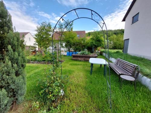 a garden with a bench in the grass at Ferienwohnung Jäger in Viereth-Trunstadt