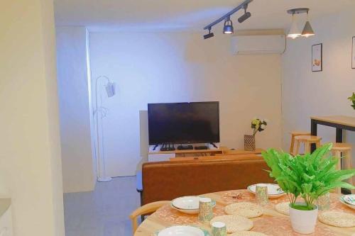 a living room with a table and a television at yourcity 台北101 和 大巨dome旁邊 大空間睡8人 in Taipei