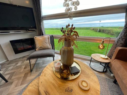 a living room with a vase on a table in front of a window at Traumblick Nr 24 aufs Wattenmeer Blick bis nach Texel in Westerland