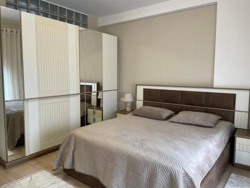a bedroom with a large bed and a mirror at Adra's apartment in Shkodër