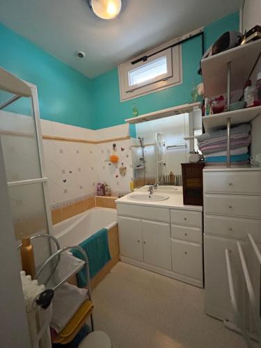 ein Badezimmer mit einer Badewanne, einem Waschbecken und einem Spiegel in der Unterkunft PARENTHÈSE Chambre Cosy proche Centre et Gare in Angoulême
