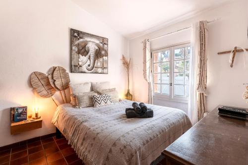 a bedroom with a bed with an elephant picture on it at Terra Di Sole - Vue mer et montagne in Grosseto-Prugna