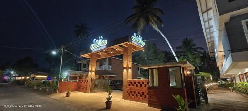 a building with a sign on it at night at Cocorico Beach Resort in Dapoli