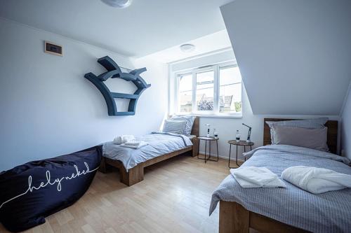 歐羅什哈佐的住宿－Helyneked，一间卧室设有两张床和窗户。