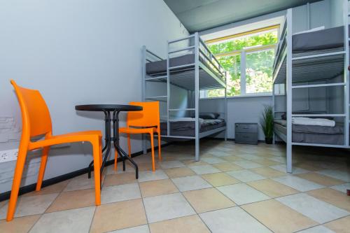 a room with a table and chairs and bunk beds at Seven Apart Hotel in Vyshneve
