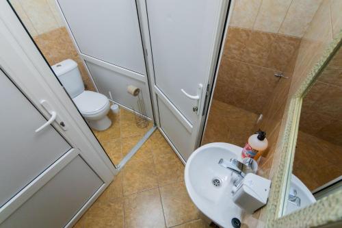a bathroom with a shower and a toilet and a sink at Seven Apart Hotel in Vyshneve
