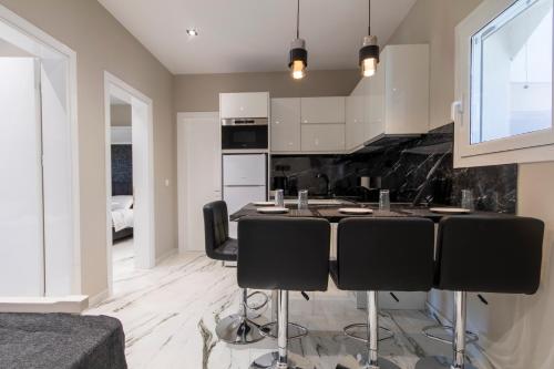 a kitchen with a table and black chairs at Evelina Luxury Suites in Corfu in Ýpsos