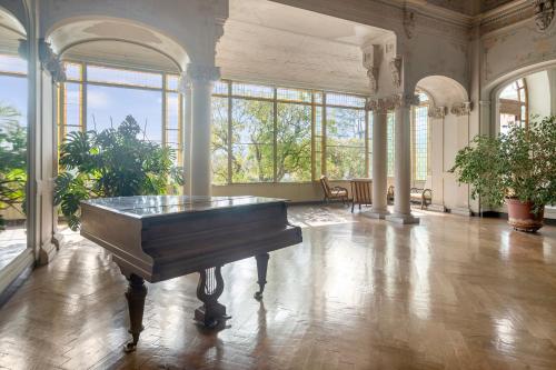 une grande pièce avec un piano au milieu dans l'établissement Riviera Palace - Happy Rentals, à Menton