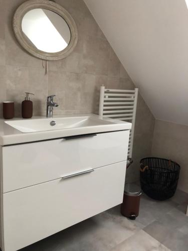 a bathroom with a white sink and a mirror at Entre terre et mer in Ploemeur