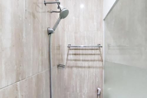 La salle de bains est pourvue d'une douche avec un pommeau de douche. dans l'établissement Ni Hotel Syariah Bandara Soekarno Hatta Mitra RedDoorz, à Selapajang