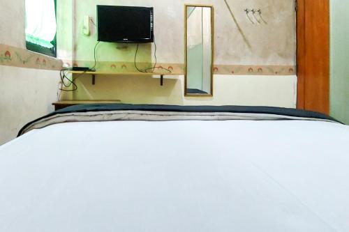Postel nebo postele na pokoji v ubytování Ni Hotel Syariah Bandara Soekarno Hatta Mitra RedDoorz