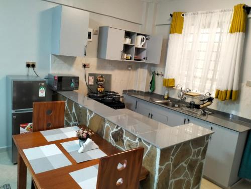 eine Küche mit einem Tisch und einer Arbeitsplatte in der Unterkunft JNJ luxury homes in Naivasha