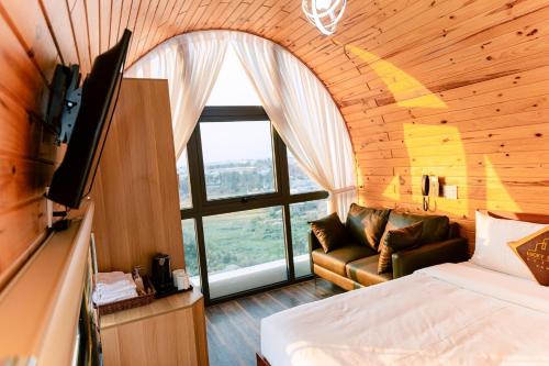 LuckyStar Hotel في بلاي كو: غرفة نوم بسرير واريكة وتلفزيون