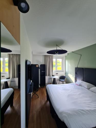 ヴァンヌにあるibis Vannesのベッドとデスクが備わるホテルルームです。