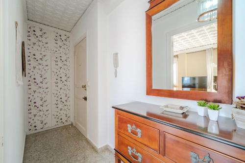 een badkamer met een houten dressoir en een spiegel bij Apartamento en puerto de javea NYK in Jávea