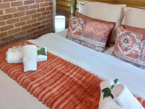 a bed with two towels and pillows on it at Riverview Spa Bed and Breakfast in Lanseria