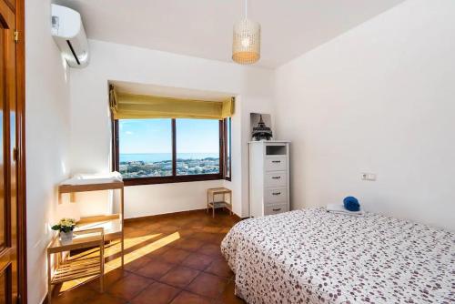 een slaapkamer met een bed en een groot raam bij Villa Mediterranea in Benalmádena