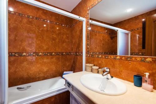 een badkamer met een wastafel en een spiegel bij Villa Mediterranea in Benalmádena
