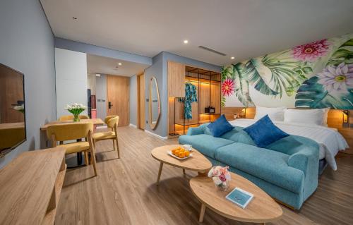 a living room with a blue couch and a bedroom at Flamingo Ibiza Hải Tiến in Nam Khê