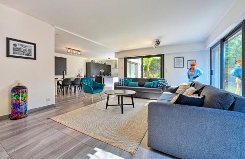 a living room with a blue couch and a table at Villa contemporaine 7 minutes du Centre de Lille in Marcq-en-Baroeul