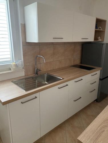 a kitchen with white cabinets and a sink at Apartments Silba in Silba