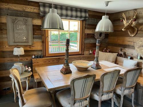 a dining room with a wooden table and chairs at Chalet Beaune - Charming and Stylish Chalet in Les Gets in Les Gets