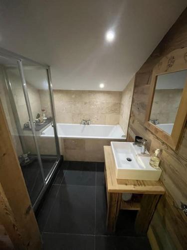 une salle de bain avec un lavabo et une baignoire dans l'établissement Chalet Beaune - Charming and Stylish Chalet in Les Gets, aux Gets