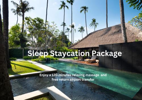 a swimming pool in a resort with palm trees at Kayumanis Jimbaran Private Villas & Spa in Jimbaran