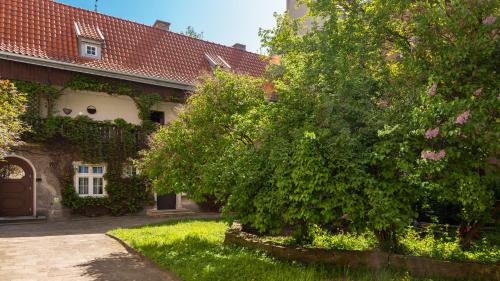 uma casa com uma árvore em frente em Flatbook - In the Heart of Old Town Apartments Mariacka em Gdansk
