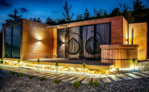 a wooden house with a deck at night at Rzepiska Hills in Rzepiska