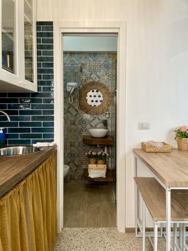 a kitchen with a sink and a bathroom with blue tiles at La Casa del Pescatore n 33 - porto di St Spirito Bari in Bari