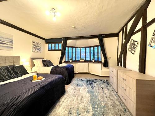 コルチェスターにあるDuchess Apt 1 Serviced 3BR Apartment in Colchester Perfect for Contractors,Temporary Housing, Relocations,Free Wifi, Secure Parkingのベッドが2つと大きな窓がある寝室