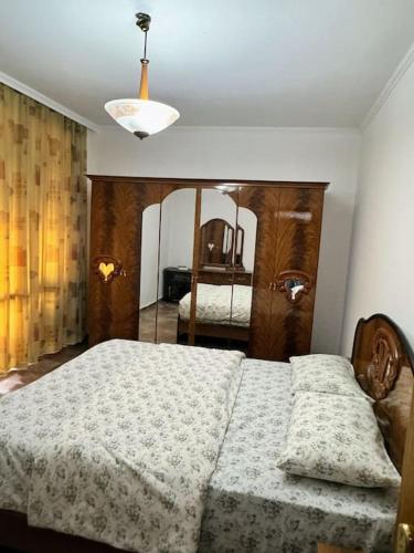 Schlafzimmer mit einem Bett und einem Spiegel in der Unterkunft Hana's Apartment - Selvia in Tirana