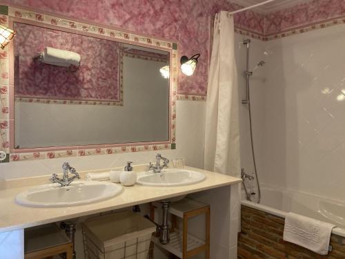 a bathroom with two sinks and a large mirror at Posada Las Torres in Yuso