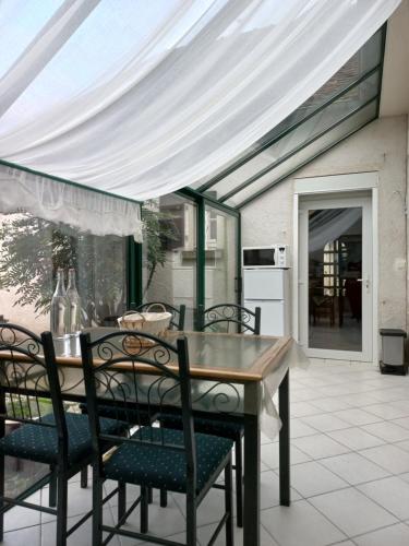 un tavolo da pranzo e sedie sotto un baldacchino bianco di La ferme du bonheur a Nouzilly