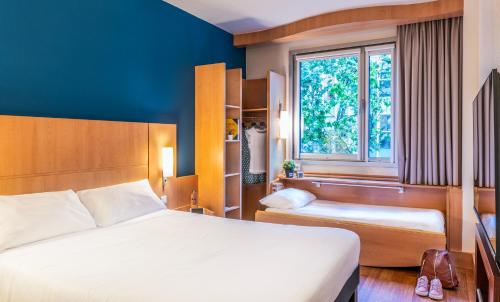 una camera d'albergo con letto e finestra di Ibis Barcelona Plaza Glòries 22@ a Barcellona