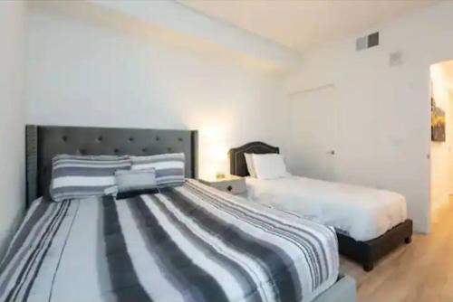 2 camas en un dormitorio con paredes blancas en San Diego Zoo in 2 miles Sleeps 7 Two Bedroom, en San Diego